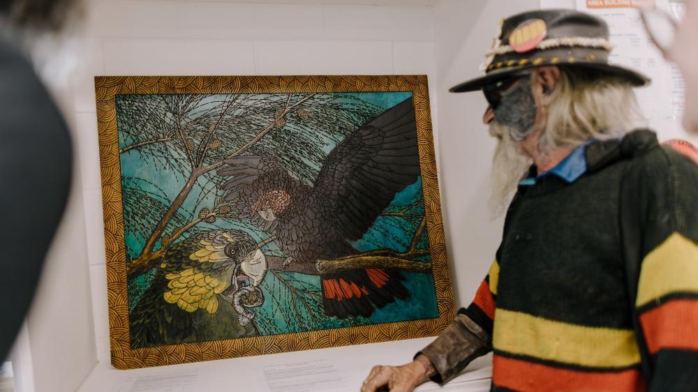 Myangah Pirate points to his artwork, featured in the exhibition. Photo: Michael Gray