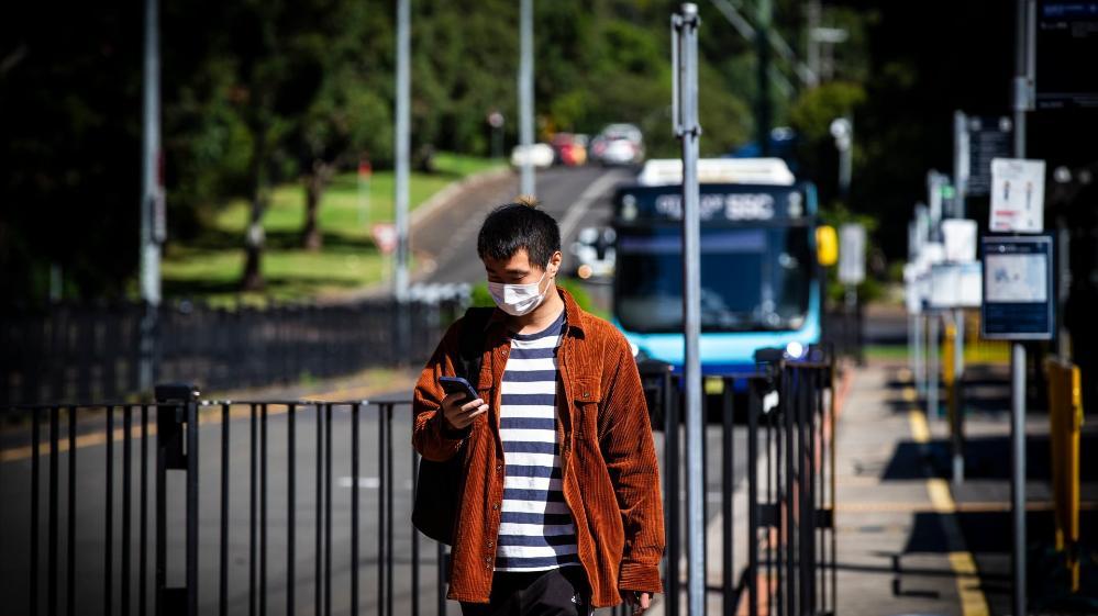A student waits for a bus at the UOW campus. Photo: Paul Jones