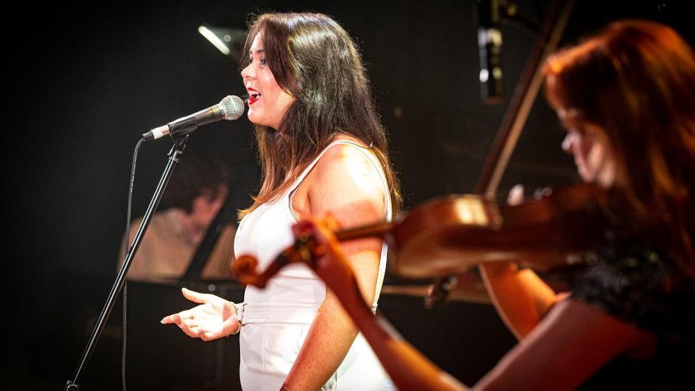 A female student performs on stage during the UOW graduate music show, Triple Fret. Photo: Paul Jones