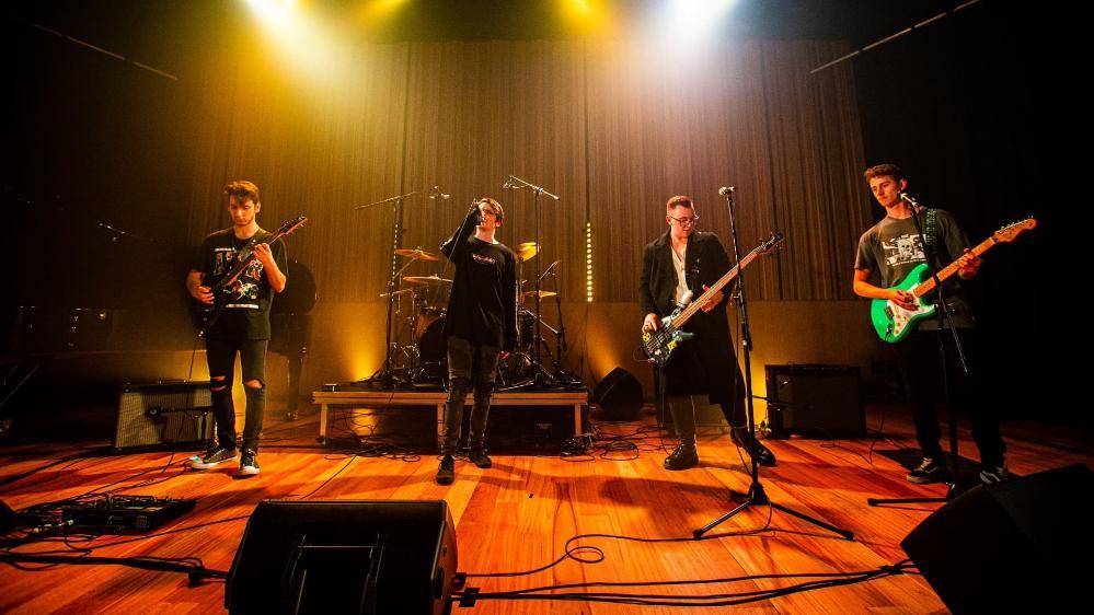 Four students play guitars on stage in the UOW graduate music show, Triple Fret. Photo: Paul Jones