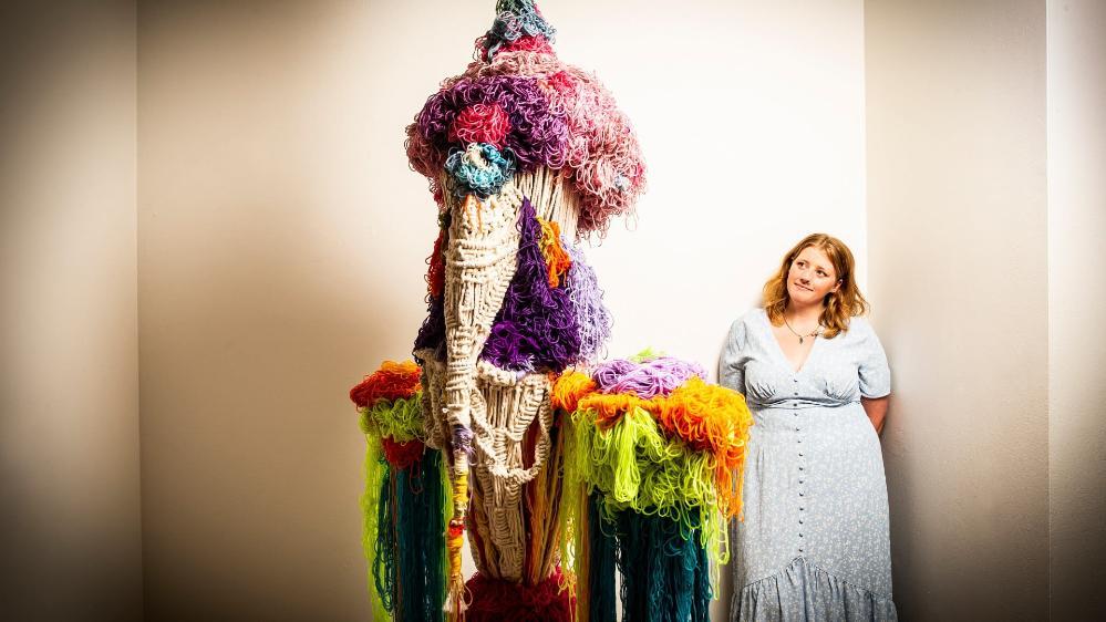 Creative arts graduate Hayley Carrick in front of her artwork in the show Zenith. Photo: Paul Jones