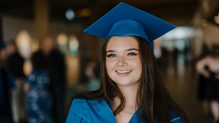 A close up image of Holli Pritchard wearing a blue gown and cap. Photo: Michael Gray
