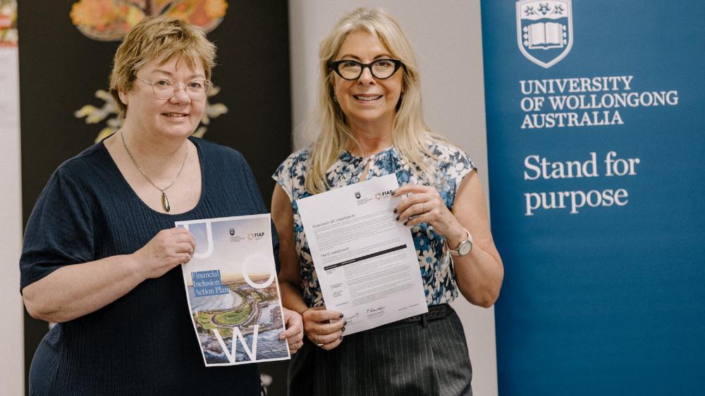 UOW Deputy Vice-Chancellor Senior Professor Eileen McLaughlin and Roslyn Russell from Good Shepherd each hold a copy of the Financial Inclusion Action Plan. Photo: Michael Gray