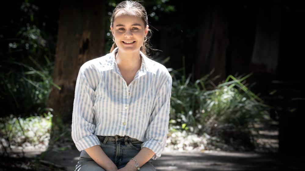 Maya Willis, wearing a light blue shirt, sits on a bench. Photo: Paul Jones