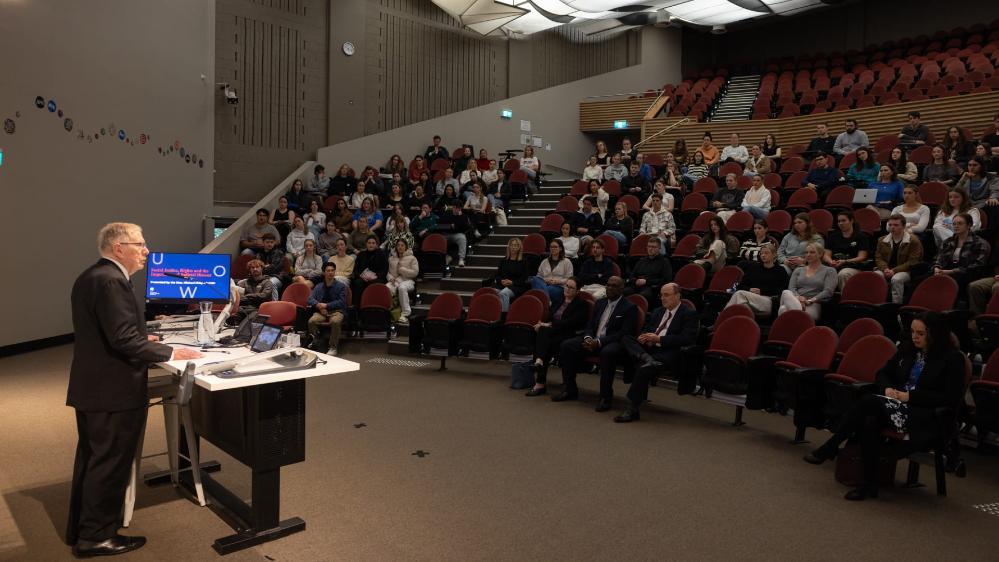 Michael Kirby delivers a lecture to a theatre full of students. Photo: Mark Newsham