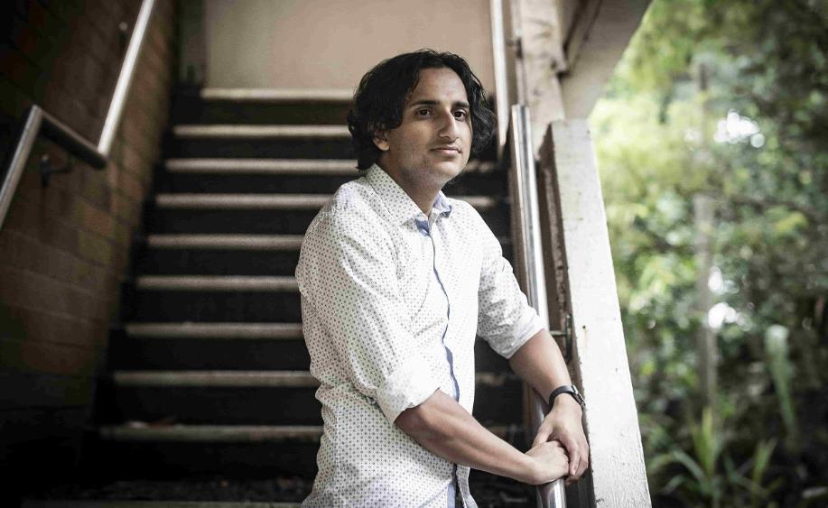 UOW student Narayan Khanal stands at the bottom of a set of stairs, and looks to the right of the image. Photo: Paul Jones