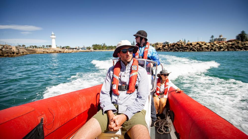 Students sit in a boat as they fish for plankton in the waters off Wollongong. Photo: Paul Jones
