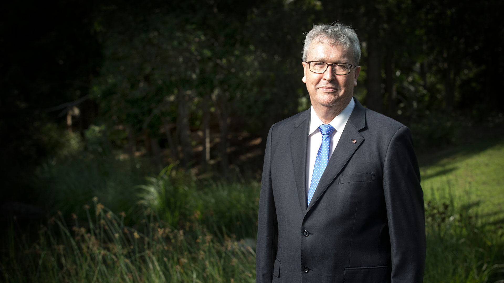Professor Paul Wellings CBE with generic campus garden background