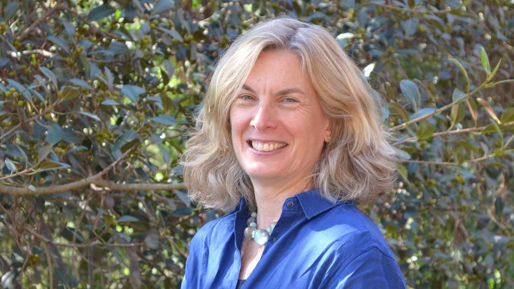 A profile image of Sharon Robinson, wearing a blue shirt, in front of a garden backdrop. Photo: Supplied