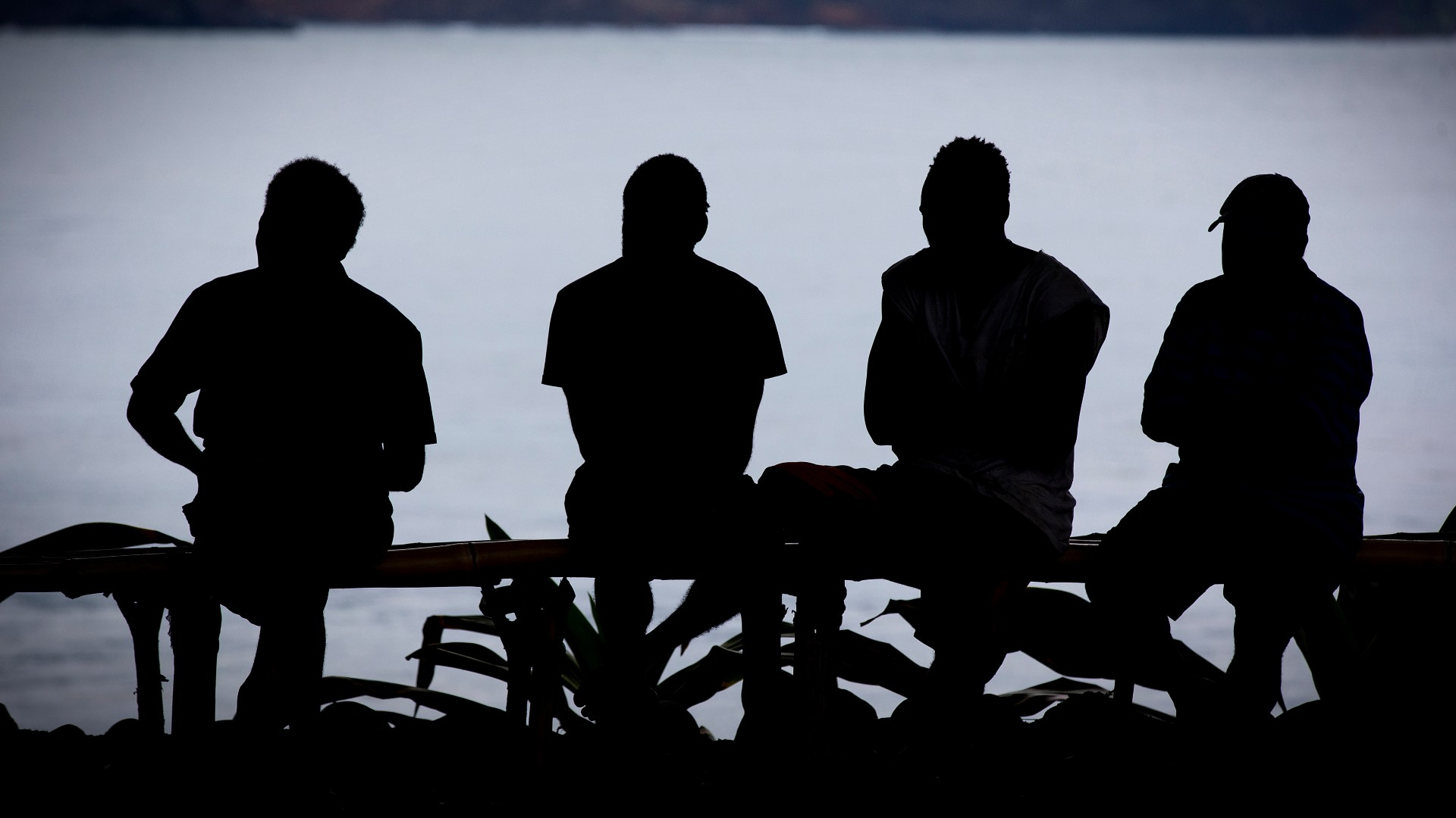 Four men are silhouetted against the ocean in Vanuatu. Photo: Paul Jones