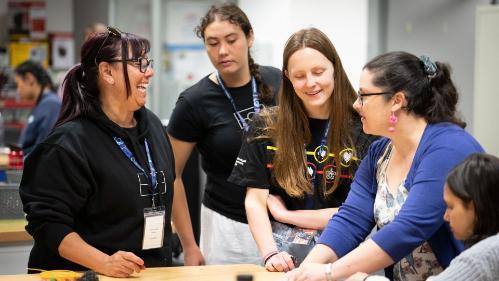 A representative from UOW works with four students from Woolyungah Summer Camp at UOW Makerspace. Photo: Paul Jones