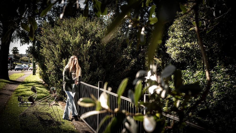 Student Tahlia Russell stands in front of a fence, surrounded by trees, at Figtree's park. Photo: Paul Jones