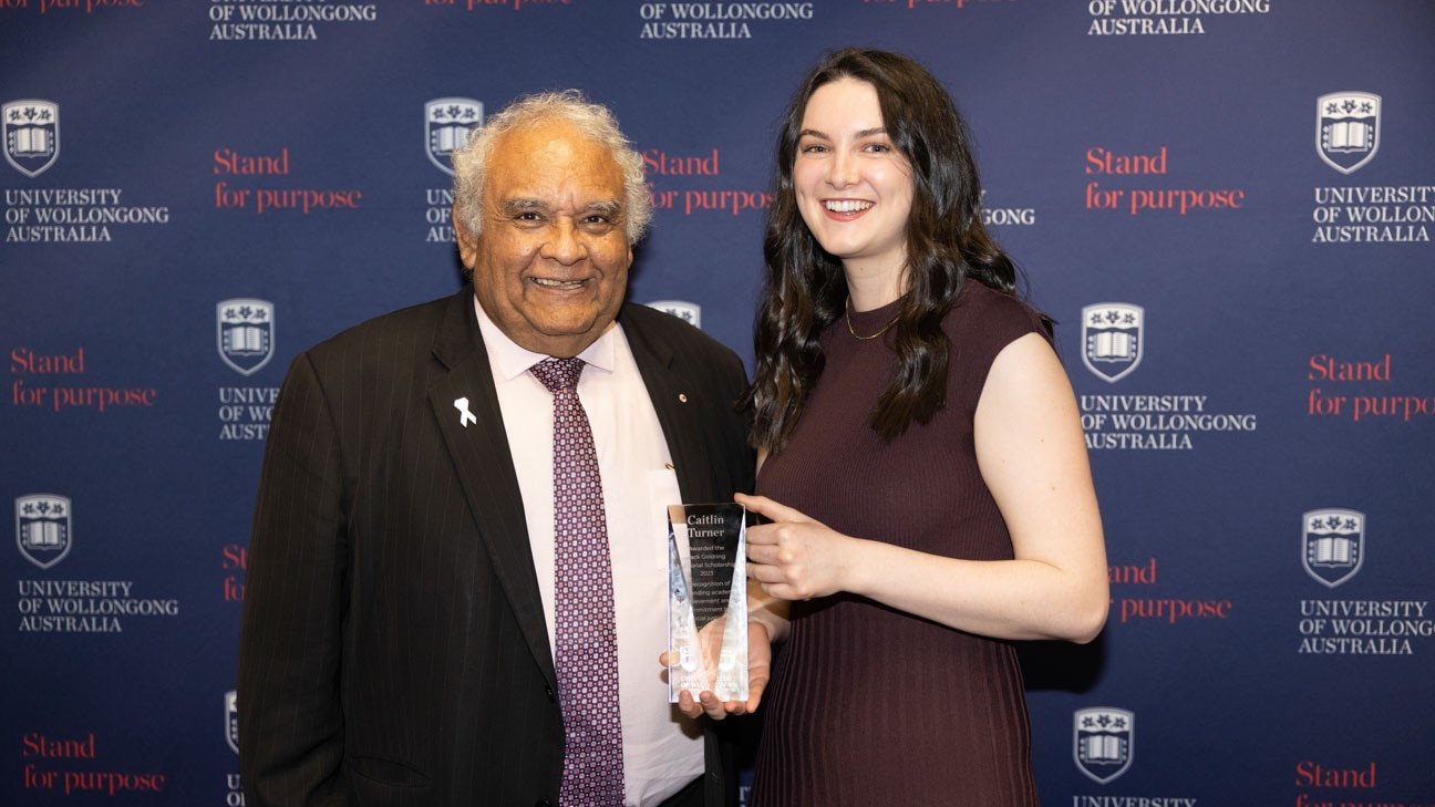 Professor Tom Calma with Goldring Scholarship winner student Caitlin Turner. They are both smiling and Caitlin holds a trophy. Photo: Mark Newsham