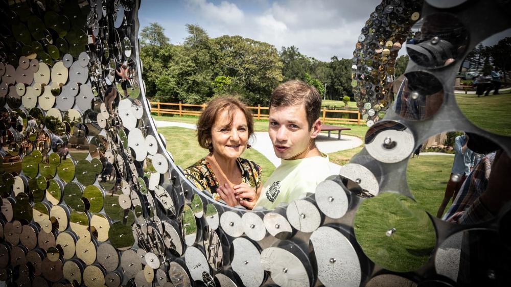 Shoshana Dreyfus and her son Bodhi look through a sparkling new artwork at the All Ages All Abilities playground in Wollongong. Photo: Paul Jones