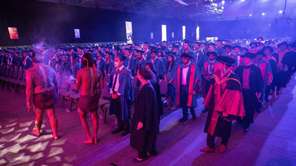A crowd of graduates look on as the academic procession enters the UOW Sports Hub for graduation. Photo: Paul JOnes