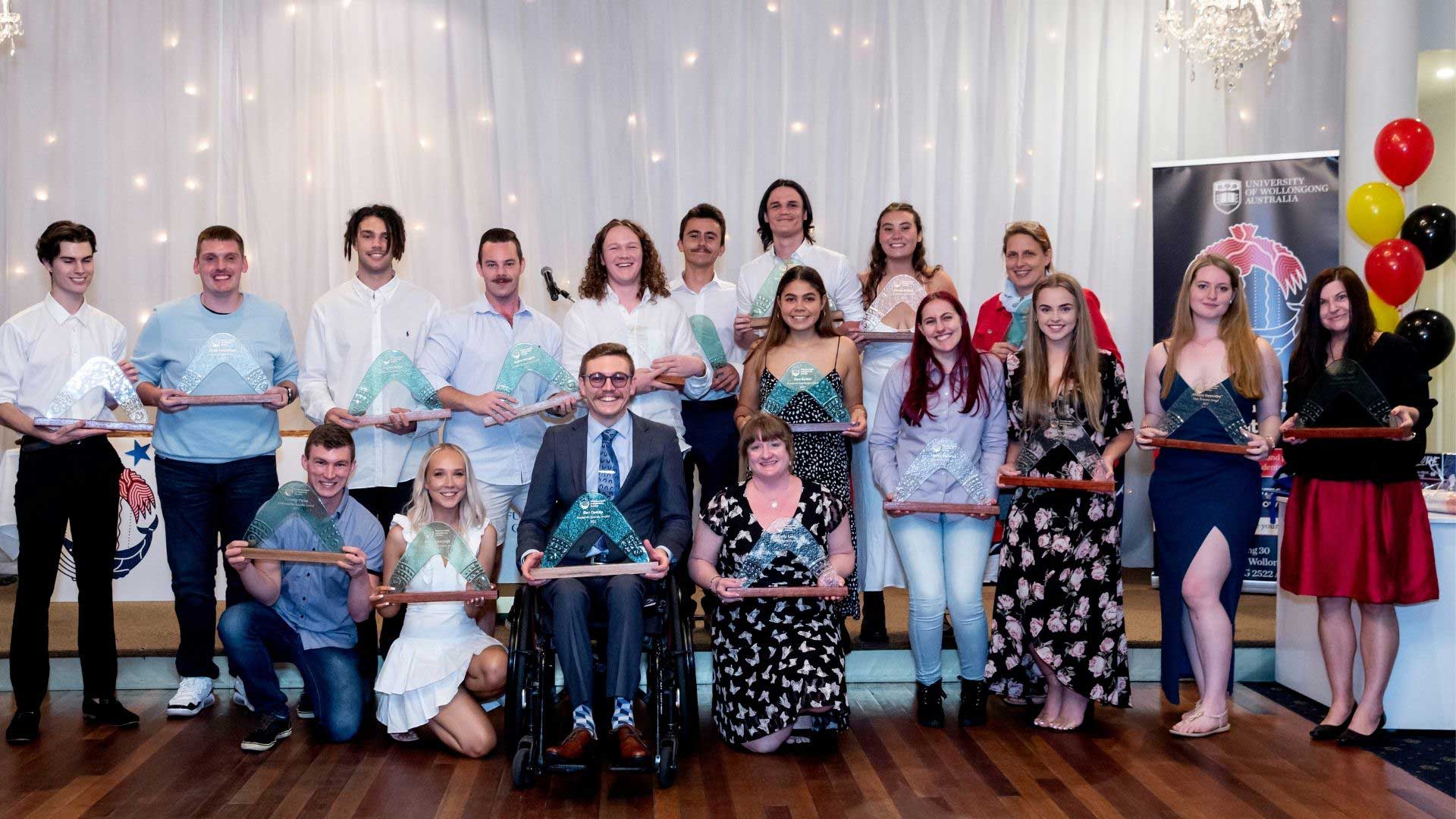 Group of 18 students holding their awards at the 2021 UOW Indigenous Students Success Awards night