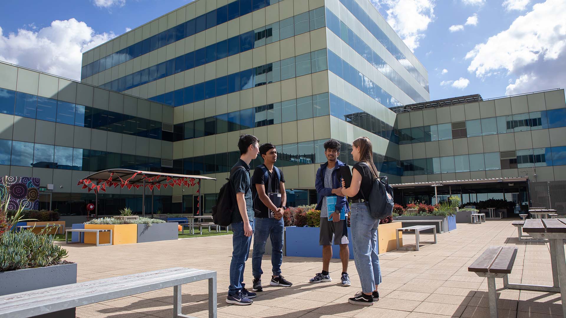 A group of students chatting outdoors at UOW's South Western Sydney campus in Liverpool