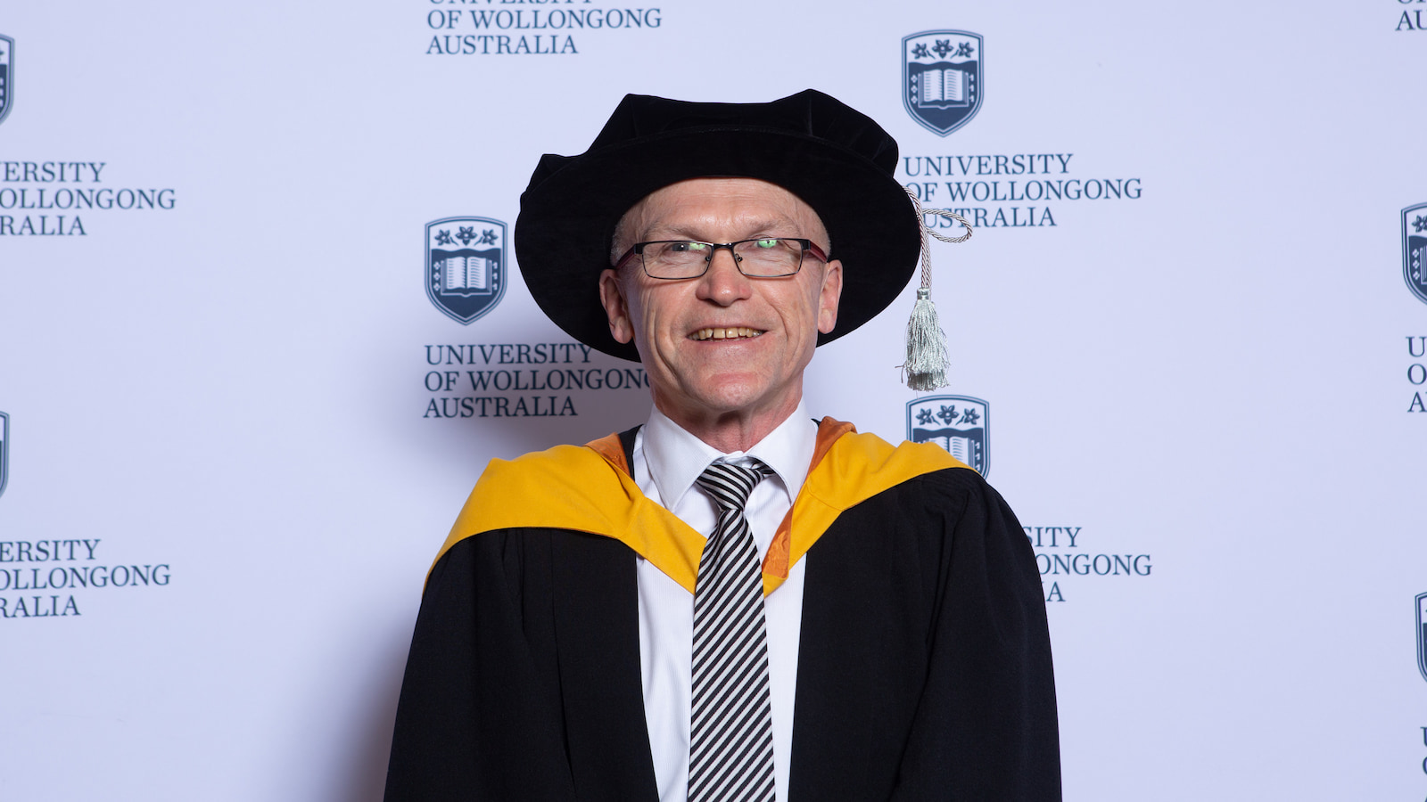 Professor Paul Cooper wears a black graduation gown and cap. Photo: Andy Zakeli