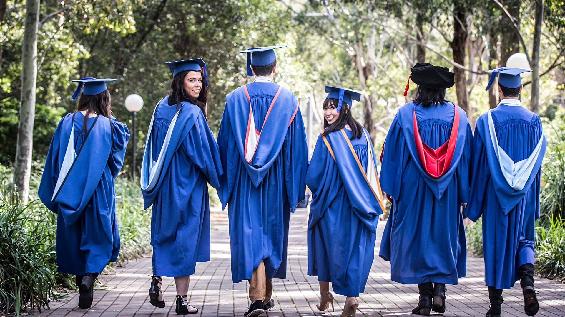 An image of six graduates with their back to the camera, pictured on Wollongong campus. Photo: Paul Jones