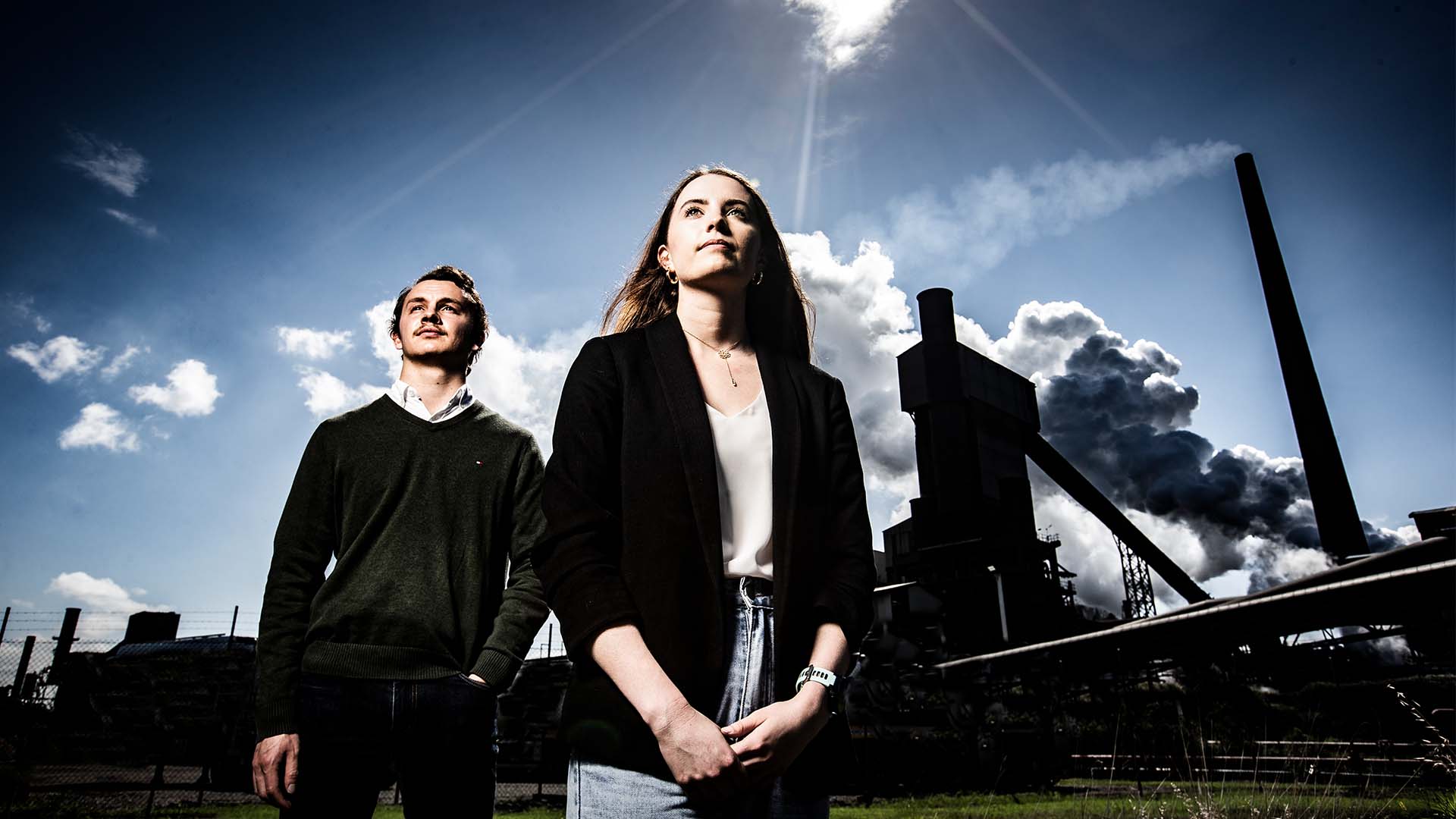 Two UOW students standing in front of Wollongong chimneys