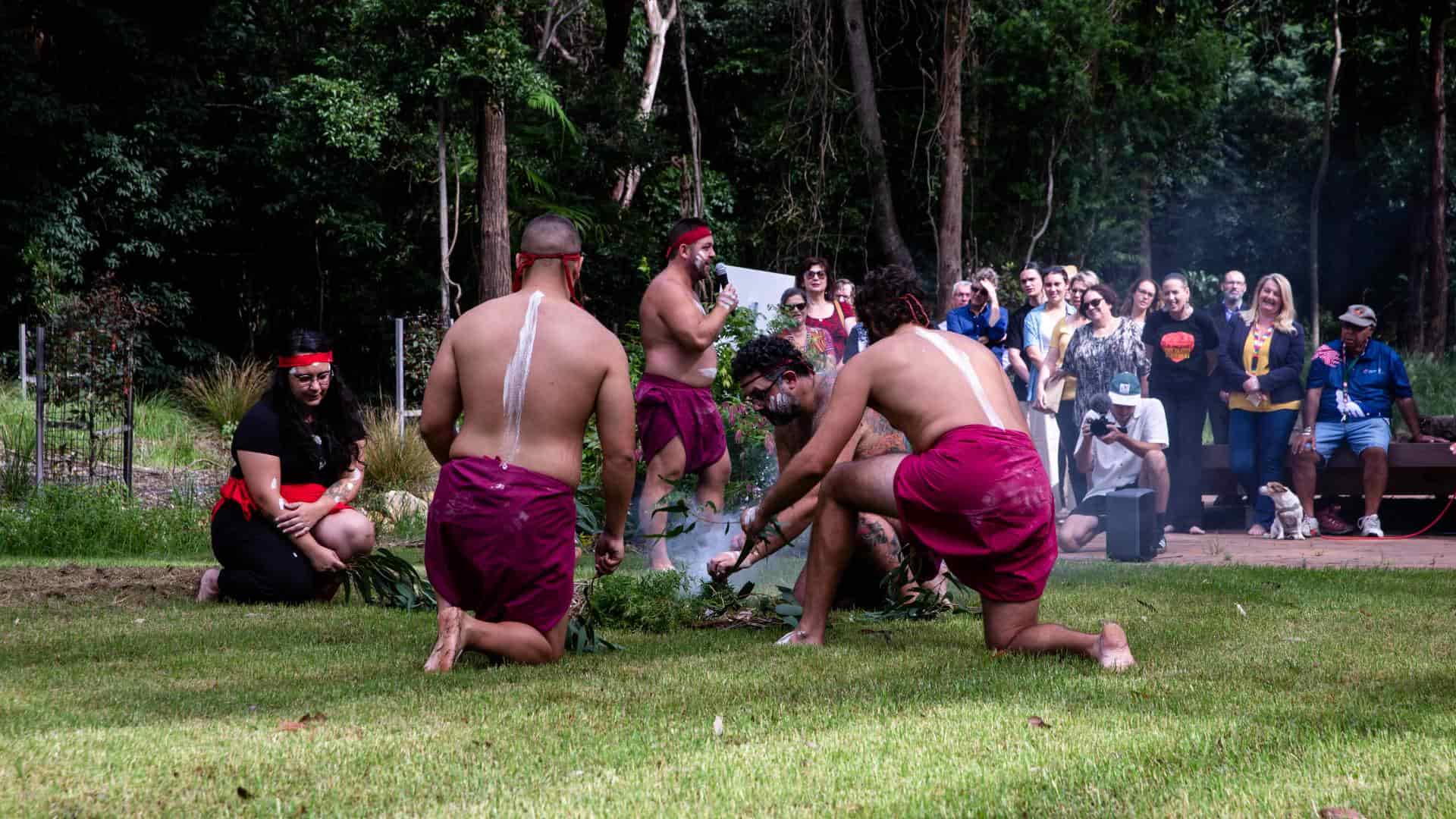 Indigenous and non-Indigenous peoples at a smoking ceremony