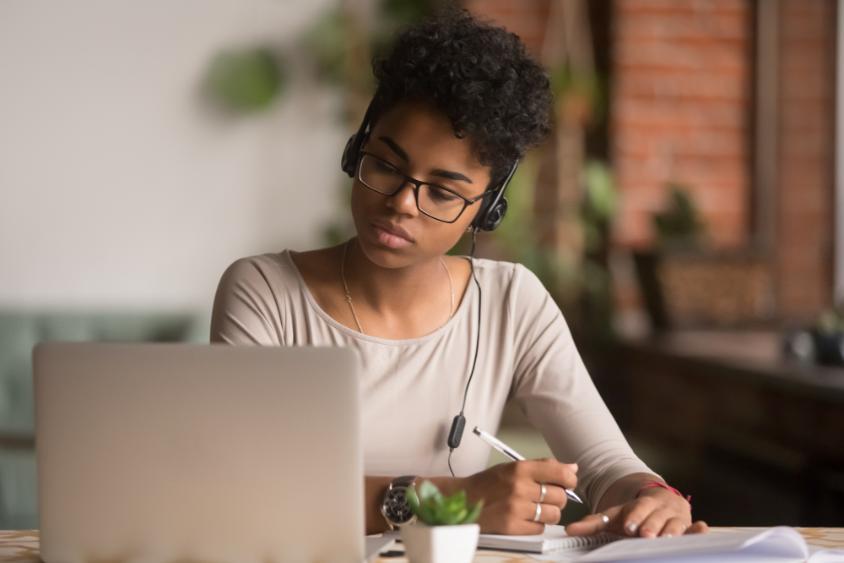 A female student studying and listening to headphones