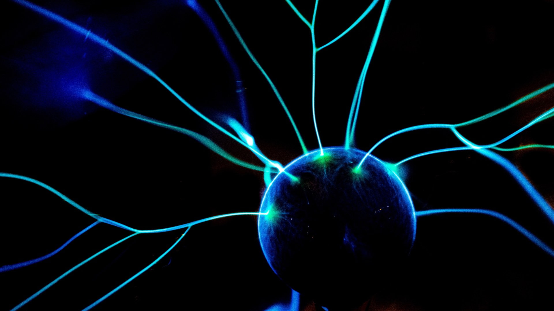 A blue and green ball with tentacles coming out of it on a black background. Photo: Unsplash