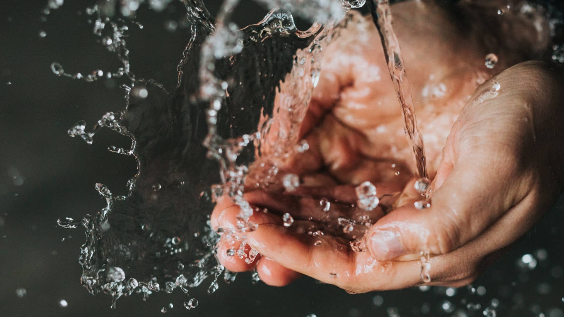 A close up of water falling on to a pair of hands. Photo: Unsplash