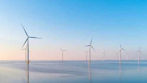 Wind power generating windmills in the ocean.