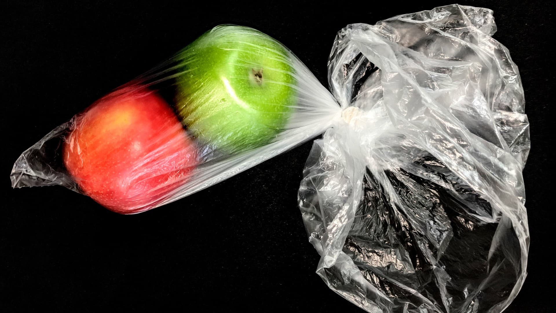 A red and green apple in a soft plastic bag. Photo: Sophie Marston/Unsplash