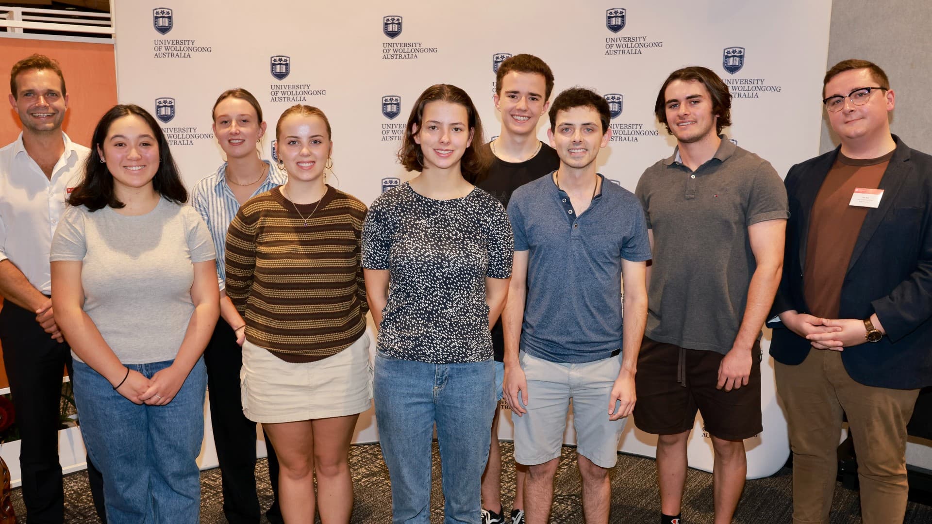 Eight students stand in front of a UOW backdrop at the Westpac Young Scholars event. Photo: Mark Newsham