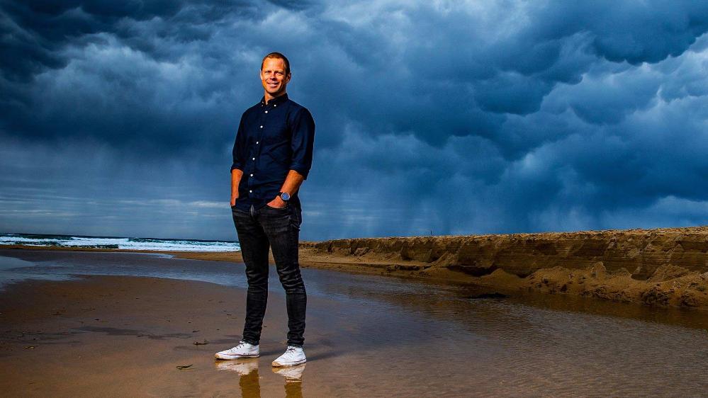 Associate Professor Hampus Eriksson, ANCORS, standing on the beach with storm clouds in background. Photo credit: Paul Jones