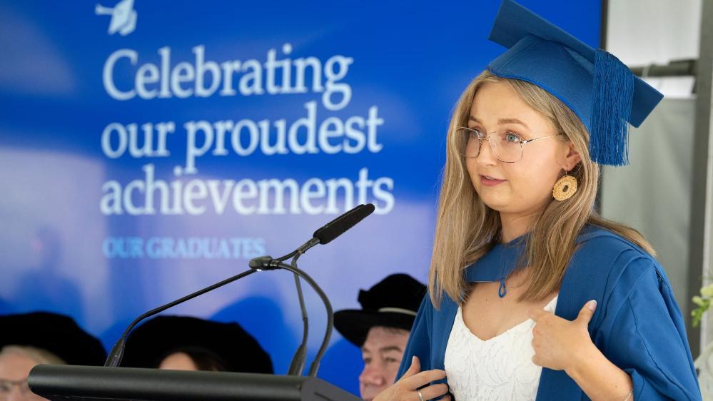 Emily Nield, wearing a blue cap and gown, delivers the Vote of Thanks to the crowd at Shoalhaven Graduations. Photo: Paul Jones