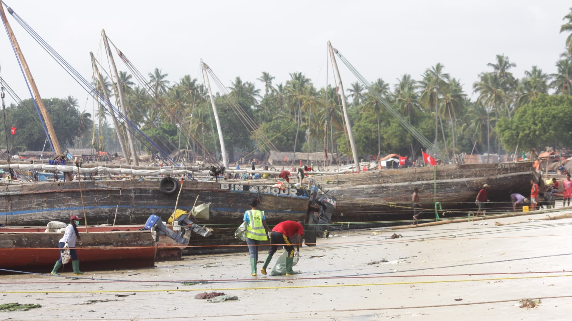 Volunteers clean up the beach in Kipumbwi in Tanzania, with fishing boats in the background. Photo: Supplied