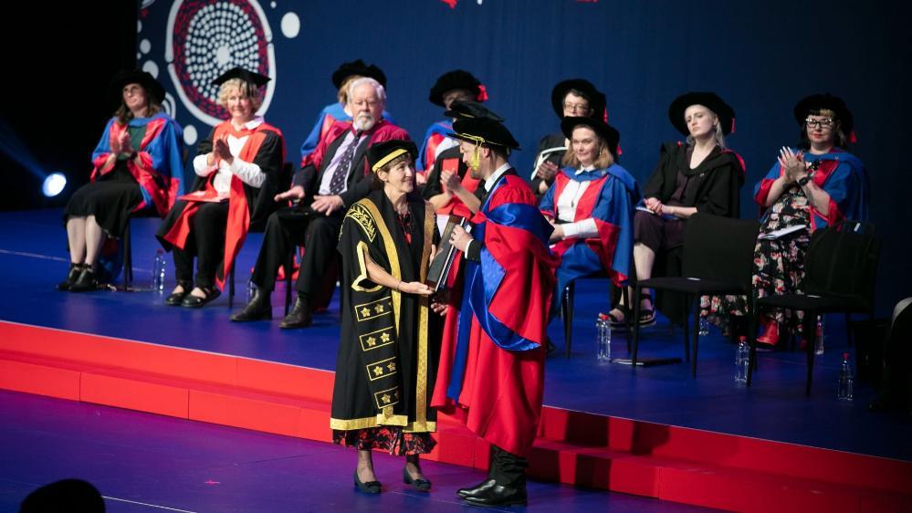 Theatre producer Michael Cassel, pictured on stage at graduation receiving his Honorary Doctorate from the Chancellor. Photo: Mark Newsham
