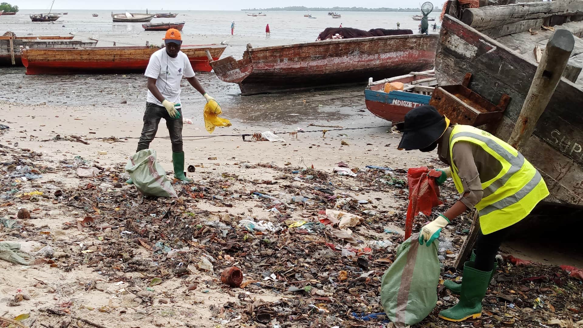Two volunteers stand next to a pile of plastic on the beach in Mkokotoni, on the coast of Zanzibar. Photo: Supplied