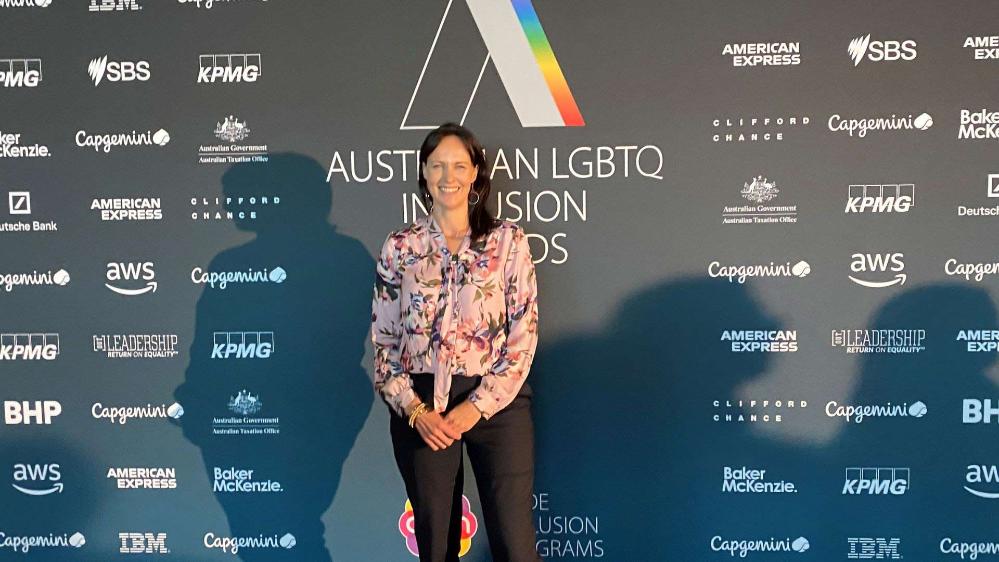 Natalie Asquith, Workforce Diversity Advisor UOW, stands behind a media wall at the 2022 Australian LGBTQ Inclusion Awards in Sydney.