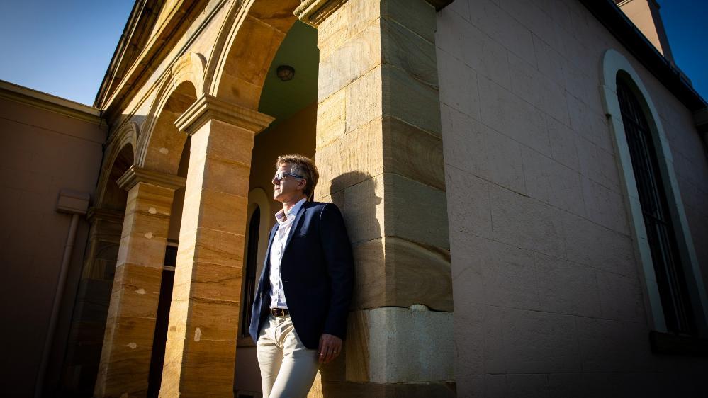 Associate Professor Nicholas Gill leans against the front of Wollongong Courthouse. Photo: Paul Jones