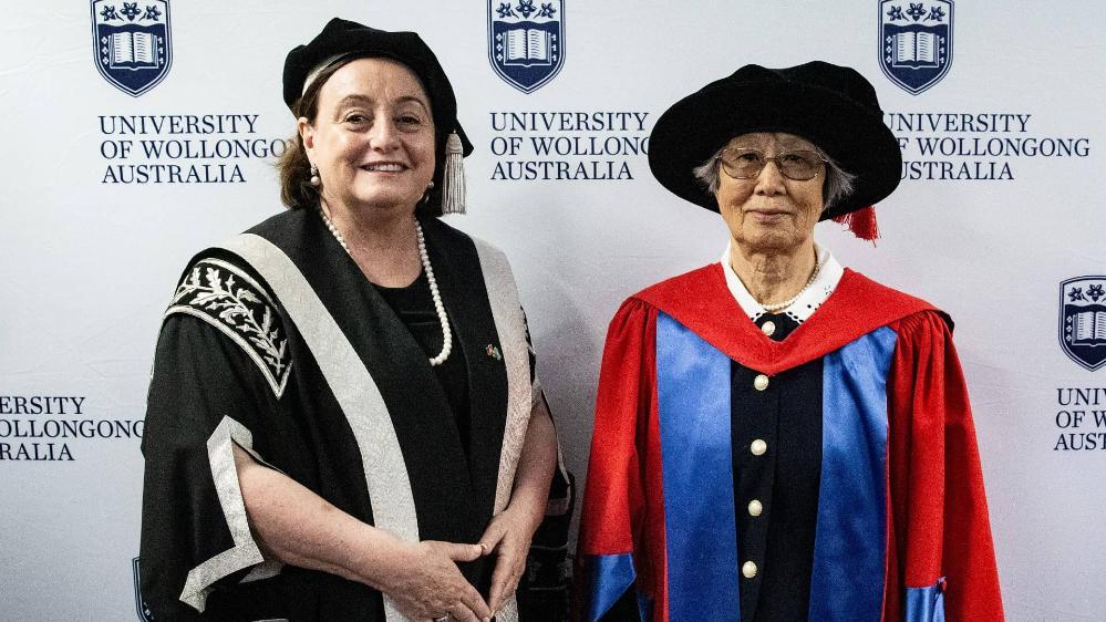 Professor Hua Kun Liu with Vice Chancellor Professor Patricia Davidson, both wearing graduation gowns and caps. Photo: Paul Jones