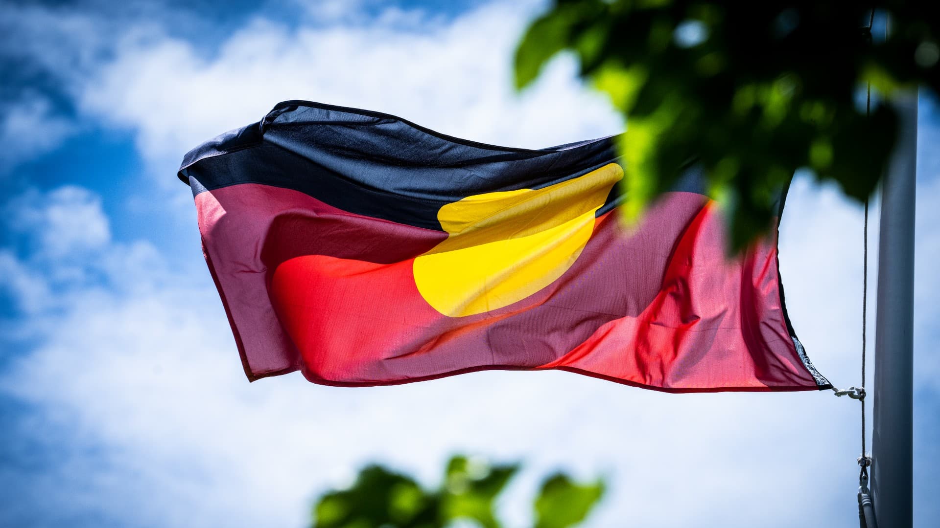 An Aboriginal flag flies against a blue sky backdrop. Photo: Paul Jones