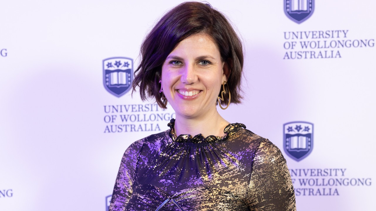 Alumni Award winner Sally O'Donnell holds her award and smiles at the camera. Photo: Mark Newsham