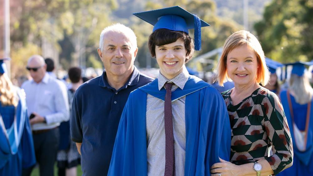 Sebastian Manfrin, pictured in his graduation gown, with his parents. Photo: Mark Newsham