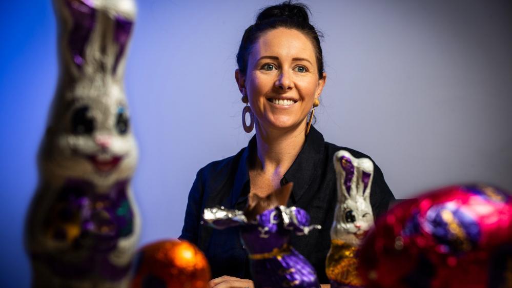 UOW researcher Dr Stephanie Perkiss sits at a table, with Easter chocolate in the foreground. Photo: Paul Jones