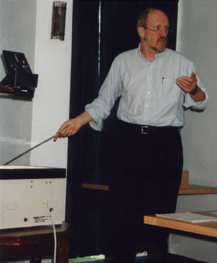 John Buckmaster simultaneously uses the pointer with his left hand whilst making a point with his right. 12th February 1999.